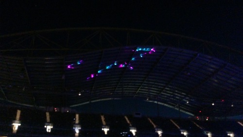 Lasers play psychedelically on the stadium roof. 